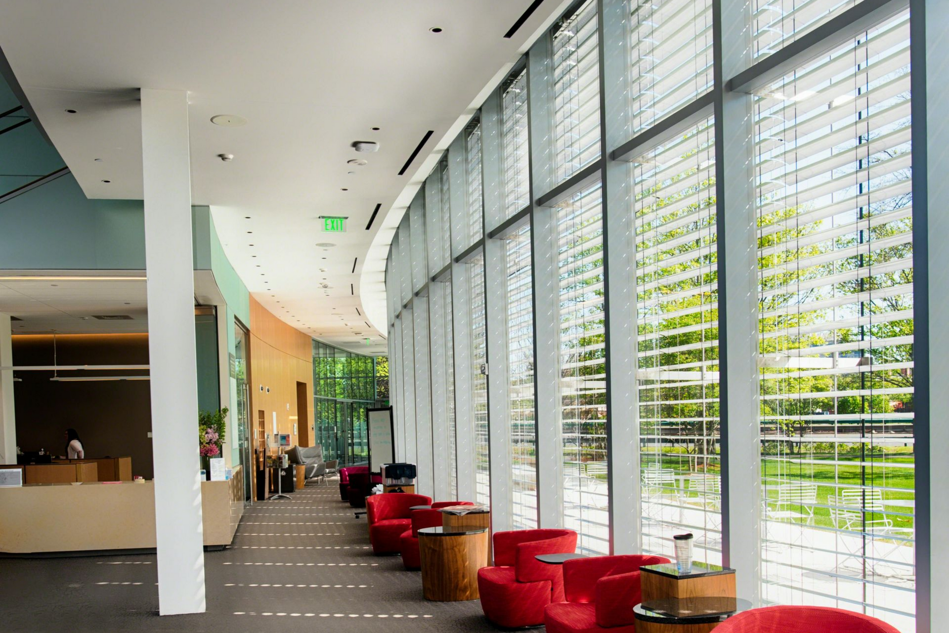 Modern curved interior with floor-to-ceiling windows and red seating.