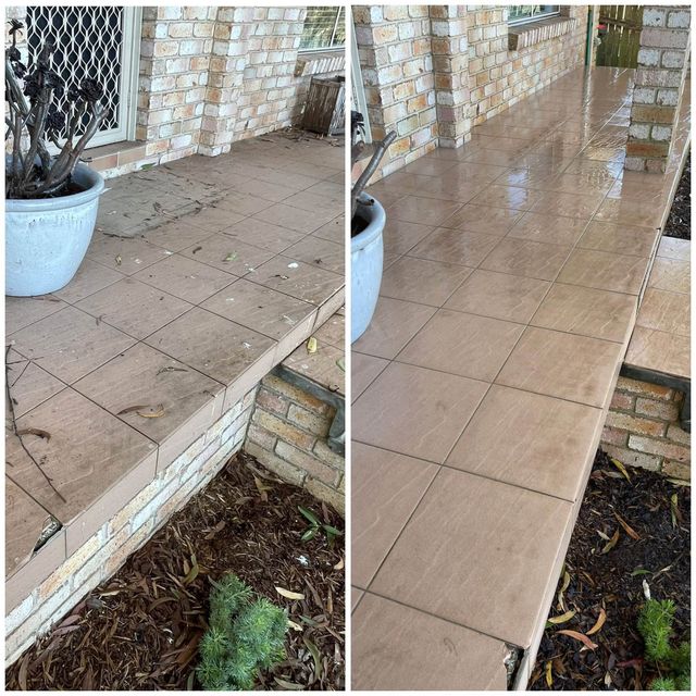 Wet tiled porch walkway beside a brick wall, showing dry tiles on the left and rainwater on the right.