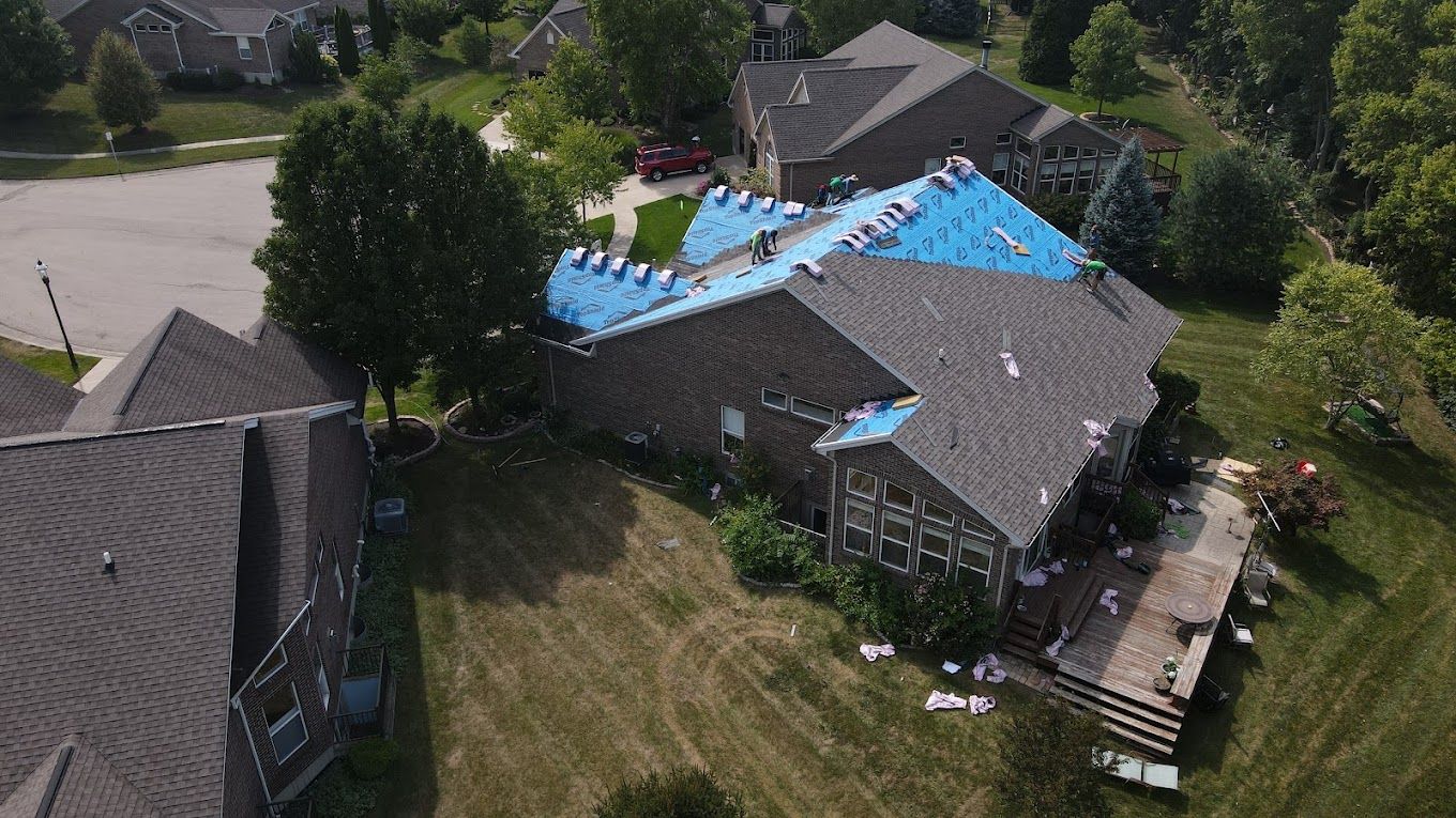 An aerial view of a house with a new roof being installed.