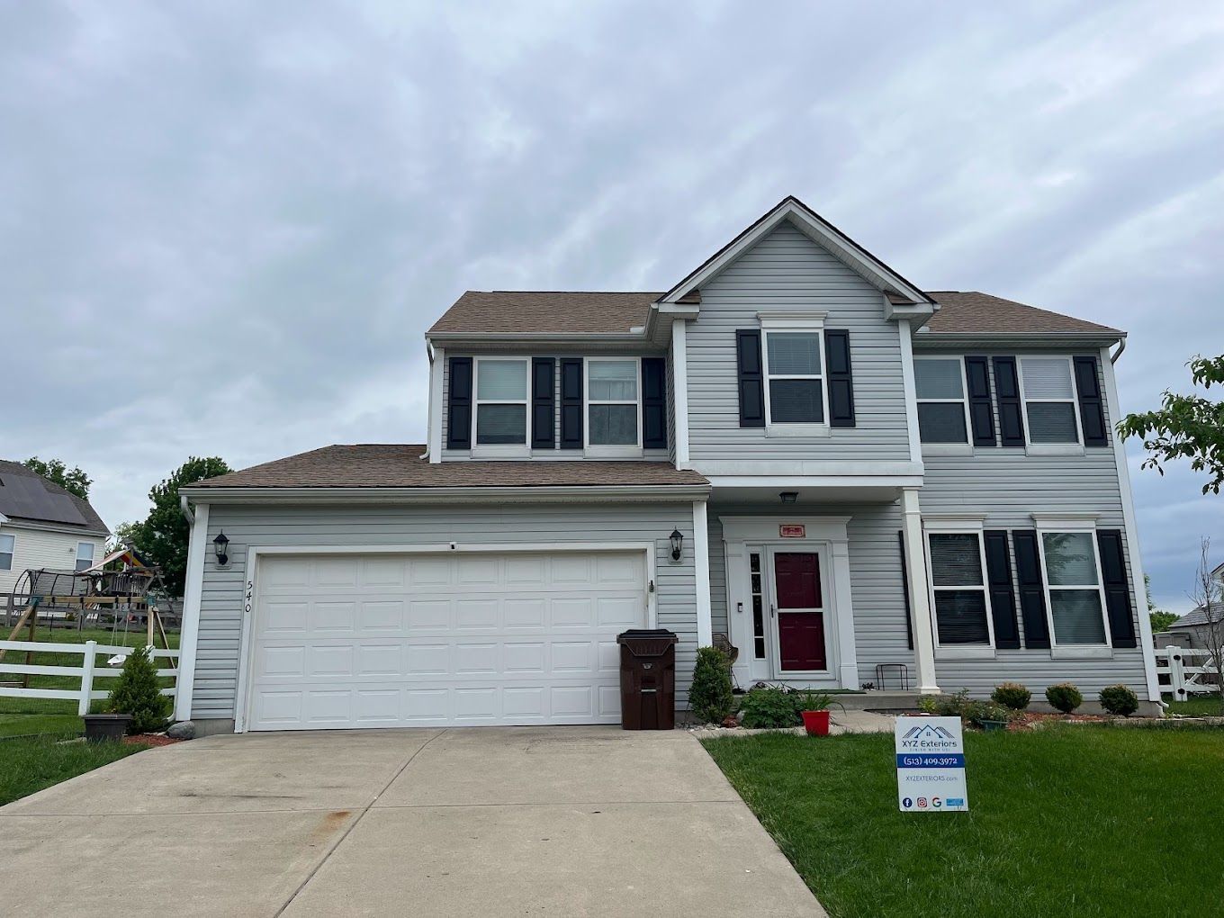 A large white house with a for sale sign in front of it.