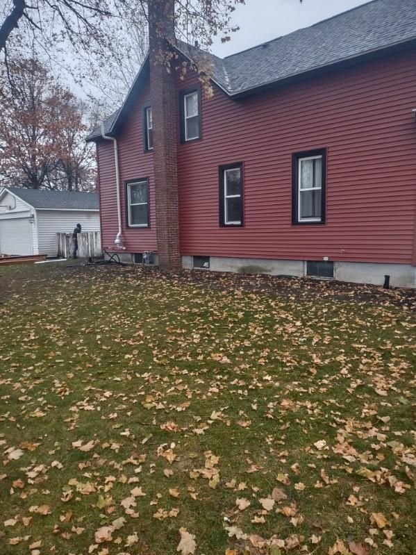 A red house with a lot of leaves on the ground