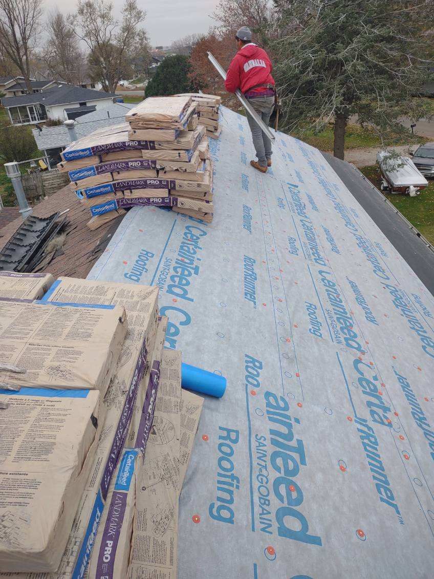 A man is working on the roof of a house.