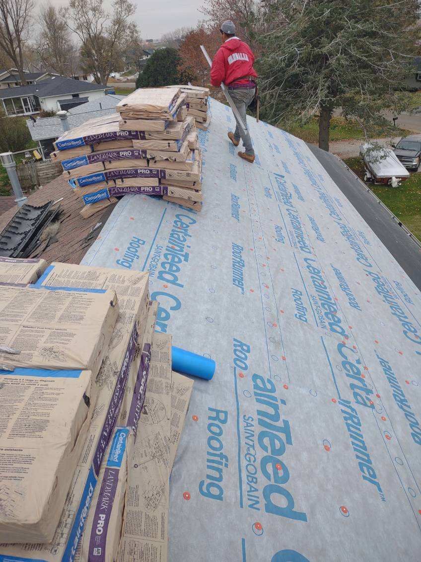 A man is working on the roof of a house.