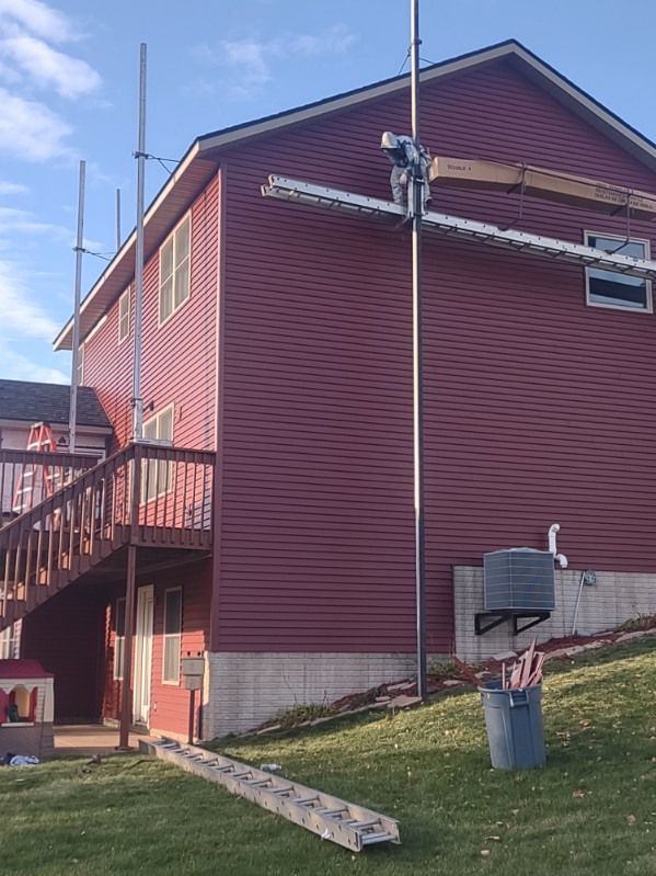 A red house with scaffolding on the side of it