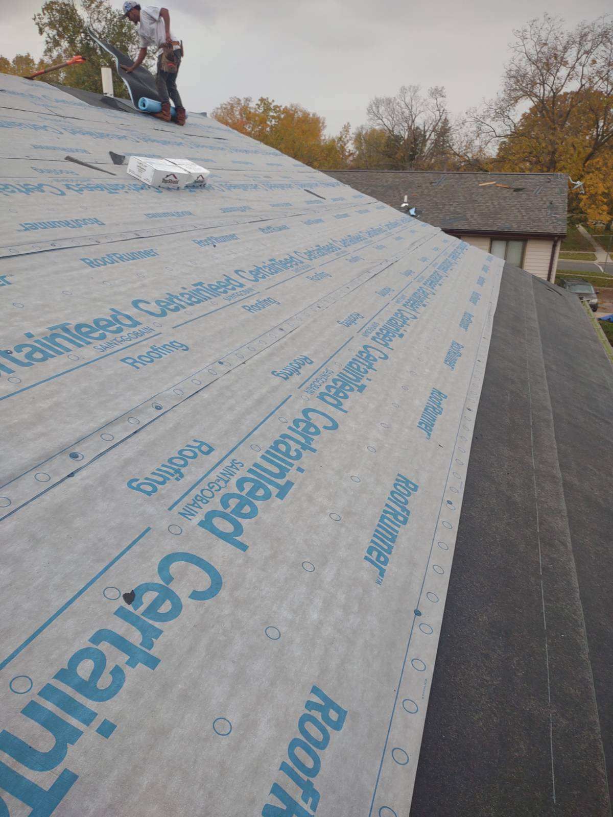 Two men are working on the roof of a house.