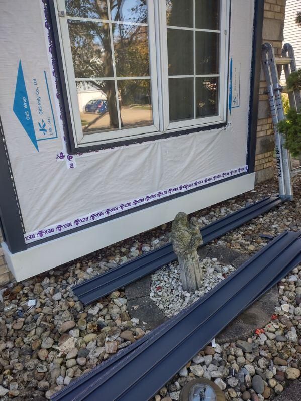 A window is being installed on the side of a house.