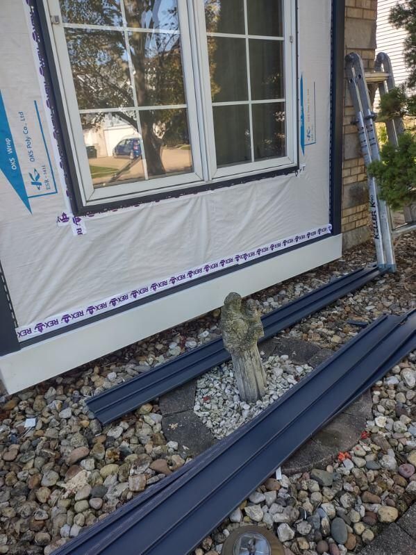 A window is being installed on the side of a house.