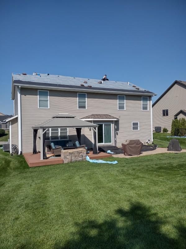 The backyard of a house with a gazebo and patio area.