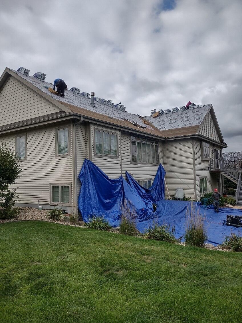 A large house with a blue tarp on the side of it.