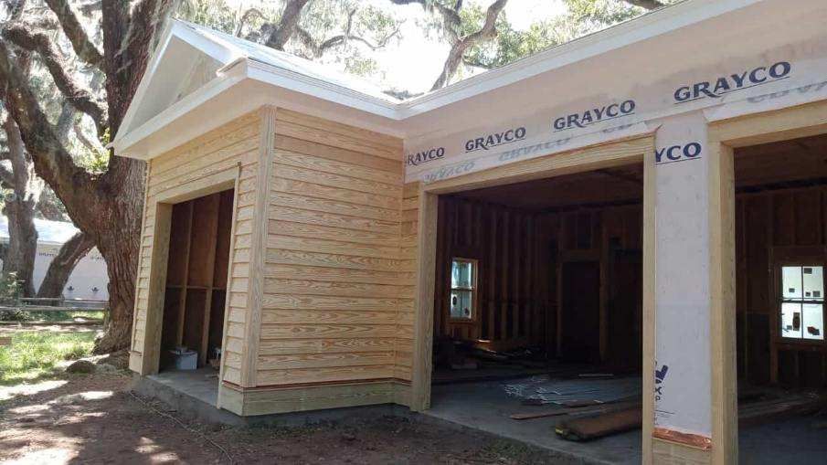 A garage is being built in the backyard of a house.