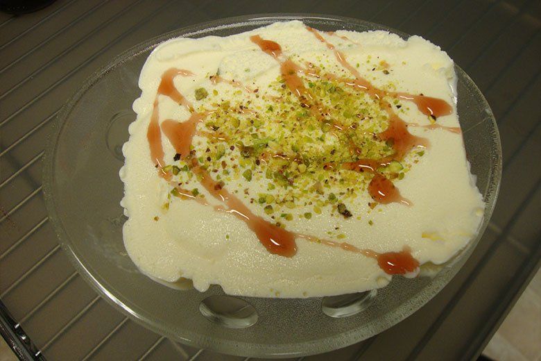 A plate of food with sauce and nuts on top