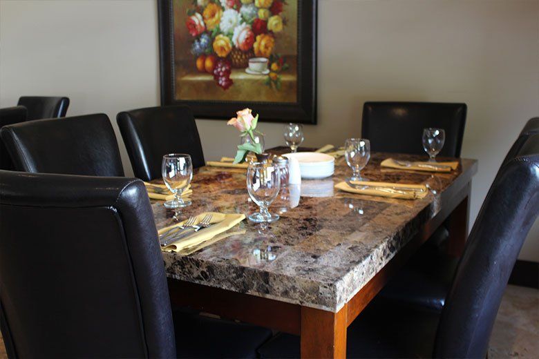 A dining room table with a vase of flowers on it