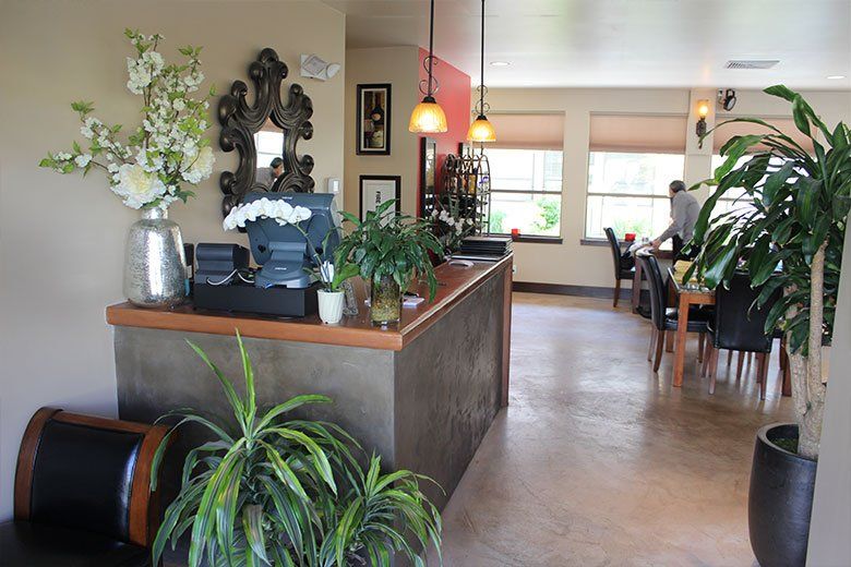 A restaurant with a counter and tables and chairs