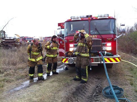 A group of firefighters are standing in front of a fire truck 