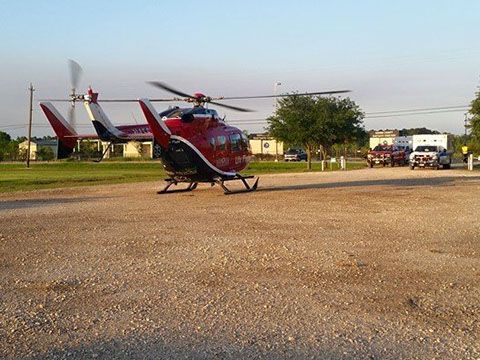 A red and white life flight helicopter is parked in a gravel lot