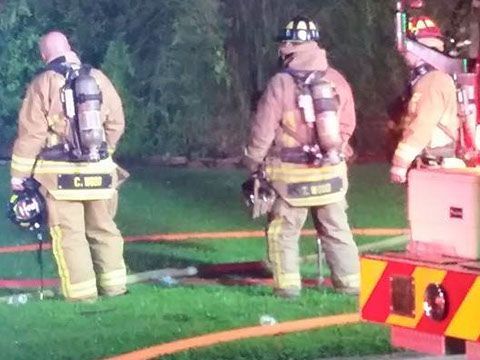A group of firefighters are standing next to a fire truck.