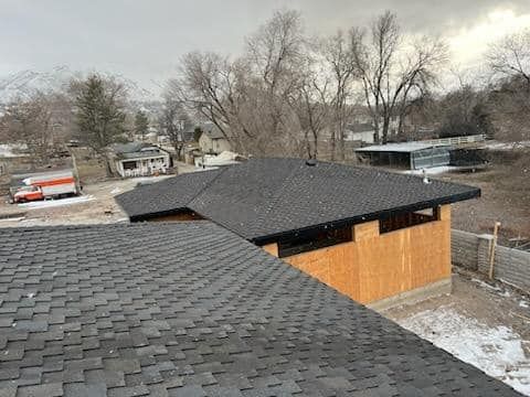 An aerial view of a house under construction with a black roof.
