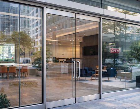 Two red and black suction cup handles attached to a car windshield for repair or removal.