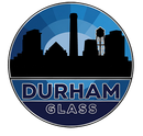 A circular logo featuring a black silhouette of the Durham skyline against a blue sunburst, with