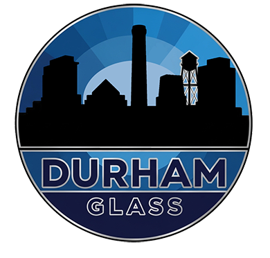 A circular logo featuring a black silhouette of the Durham skyline against a blue sunburst, with