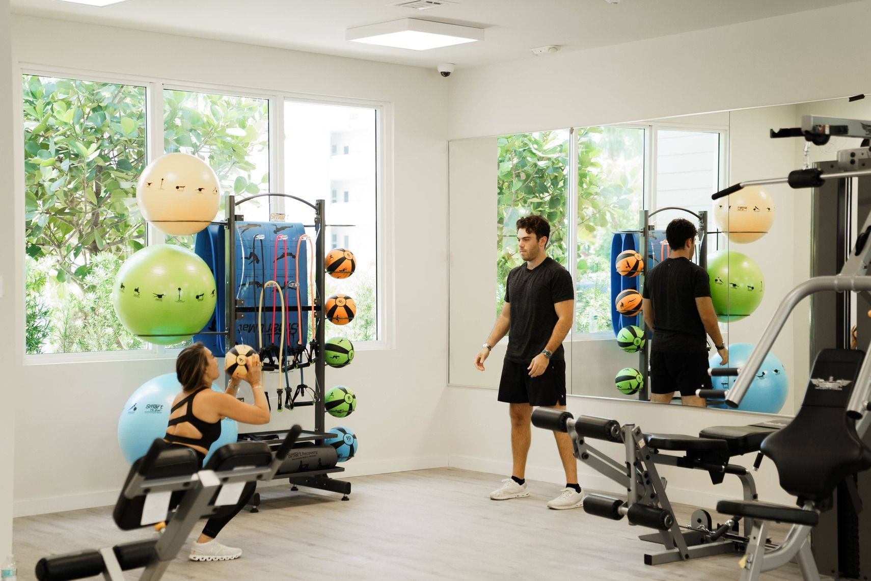 A man and a woman are working out in a gym.