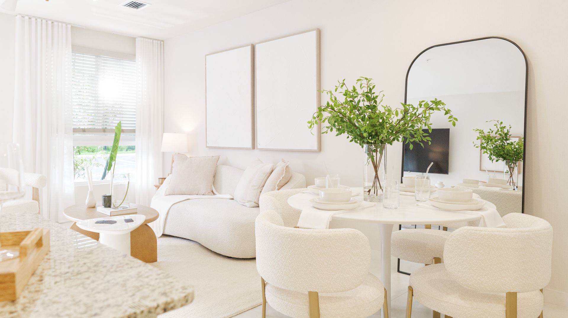 A living room with a couch , chair , coffee table and window.