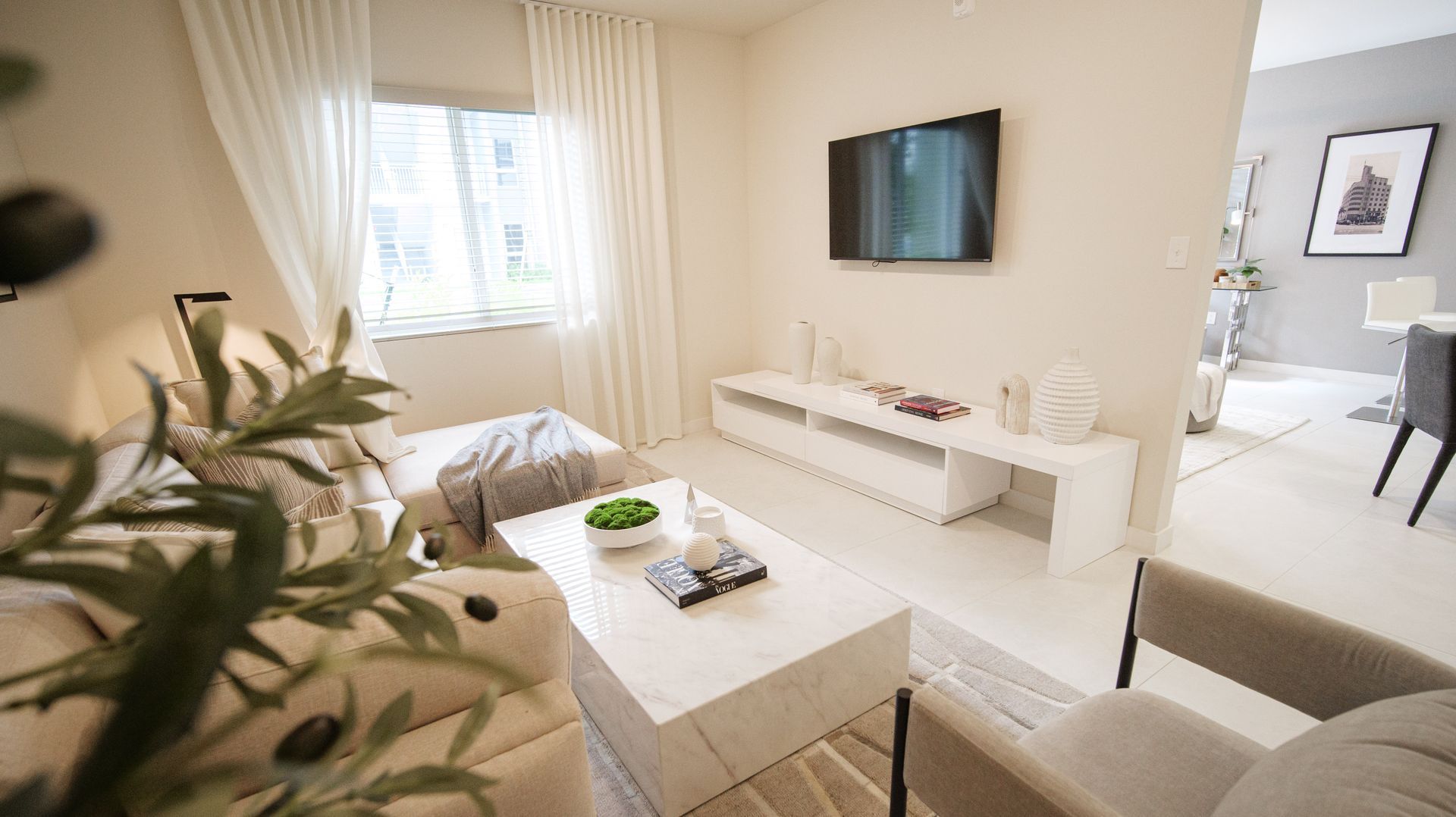 A living room with a couch , coffee table and chairs.