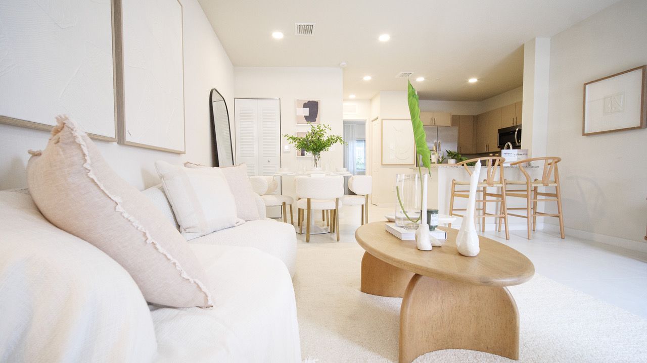 A living room with a couch , coffee table and chairs.