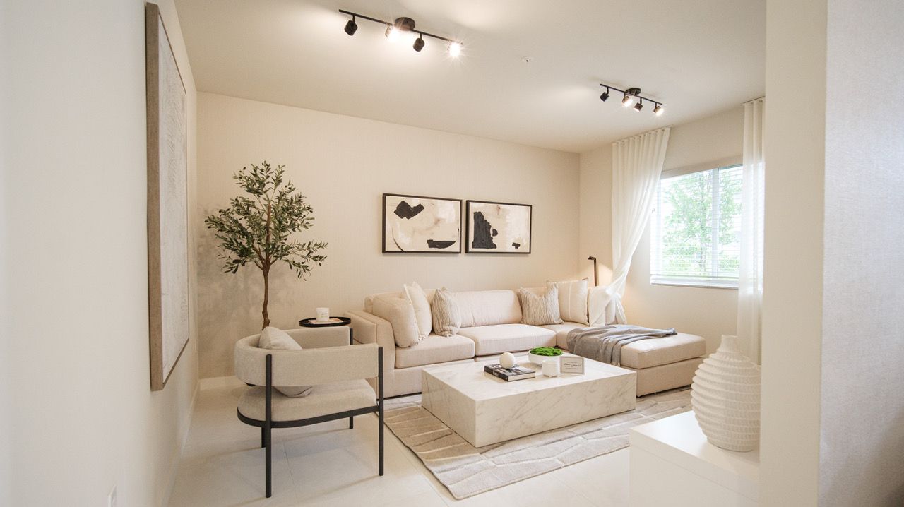 A living room with a couch , chair , coffee table and window.