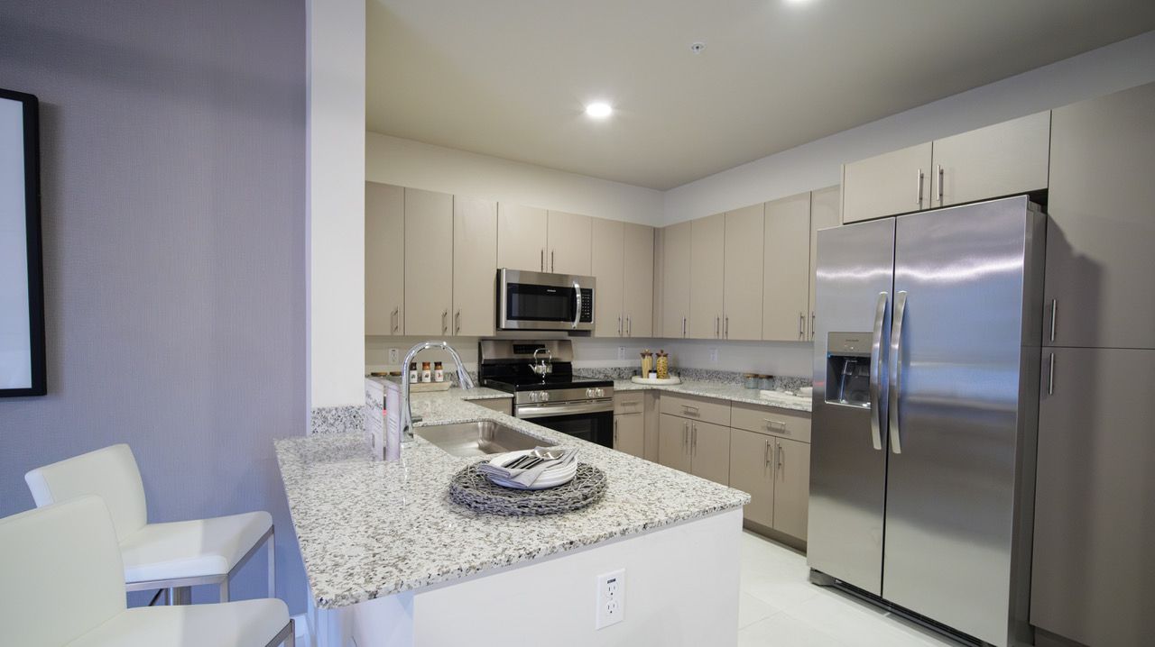 A kitchen with stainless steel appliances and granite counter tops.