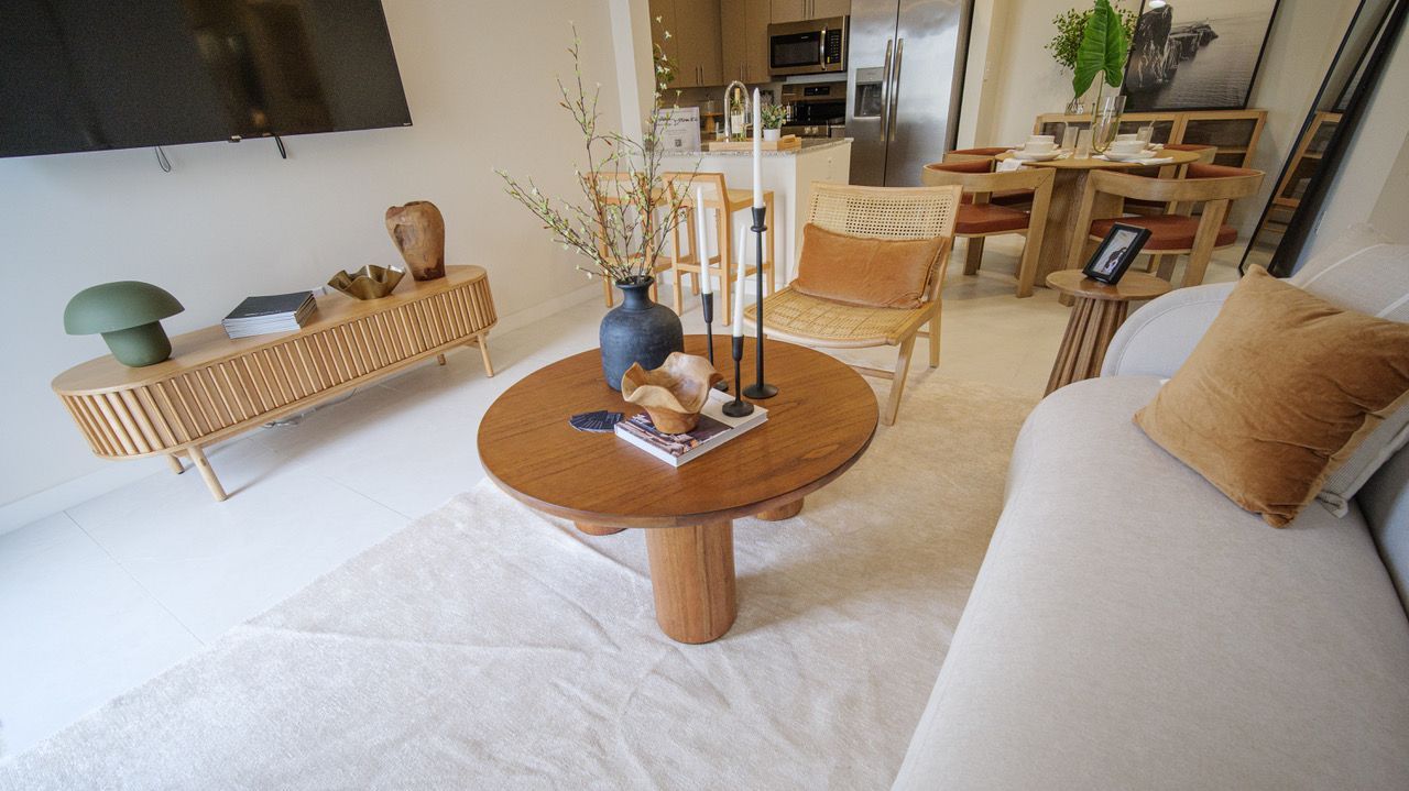 A living room with a couch , table , chairs and a television.