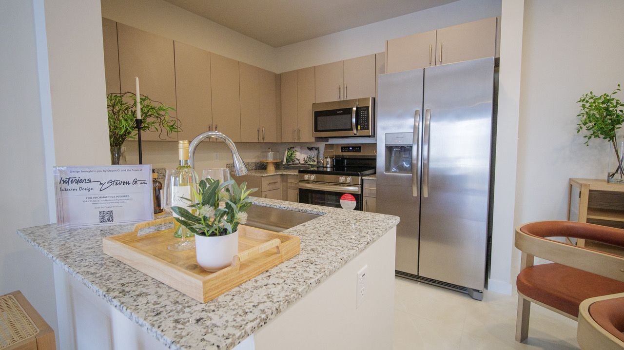 A kitchen with stainless steel appliances and granite counter tops.