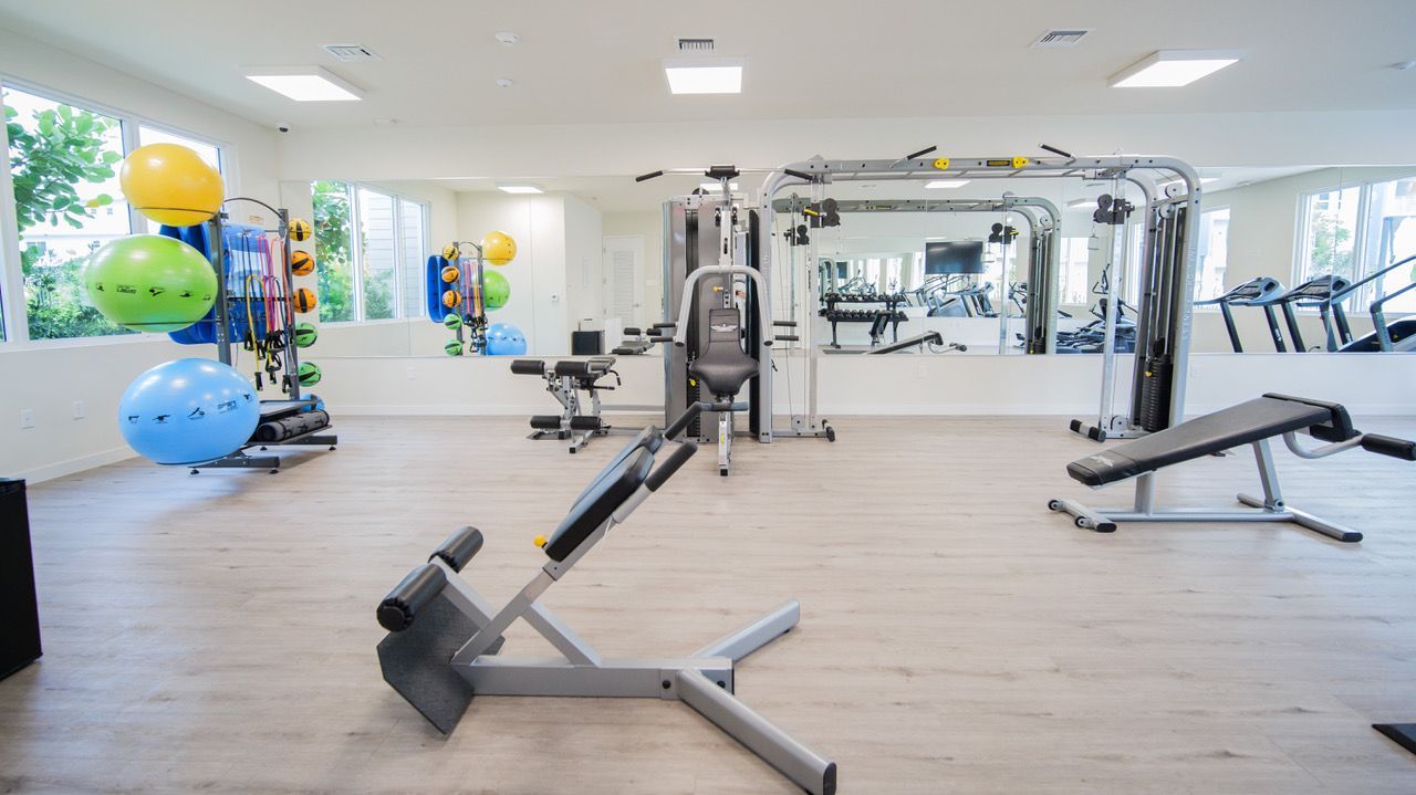A large empty gym with a lot of exercise equipment.