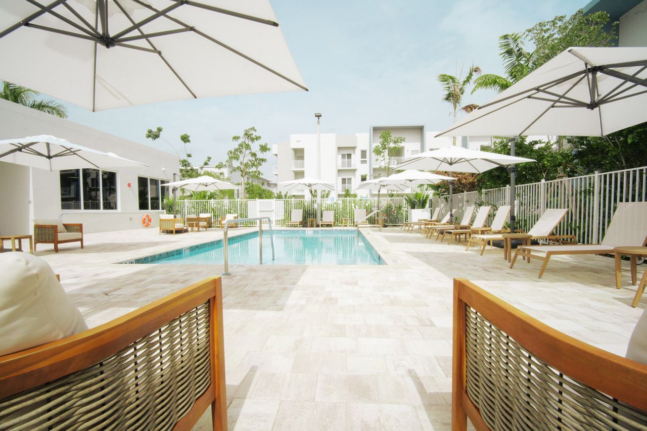 A large swimming pool surrounded by chairs and umbrellas