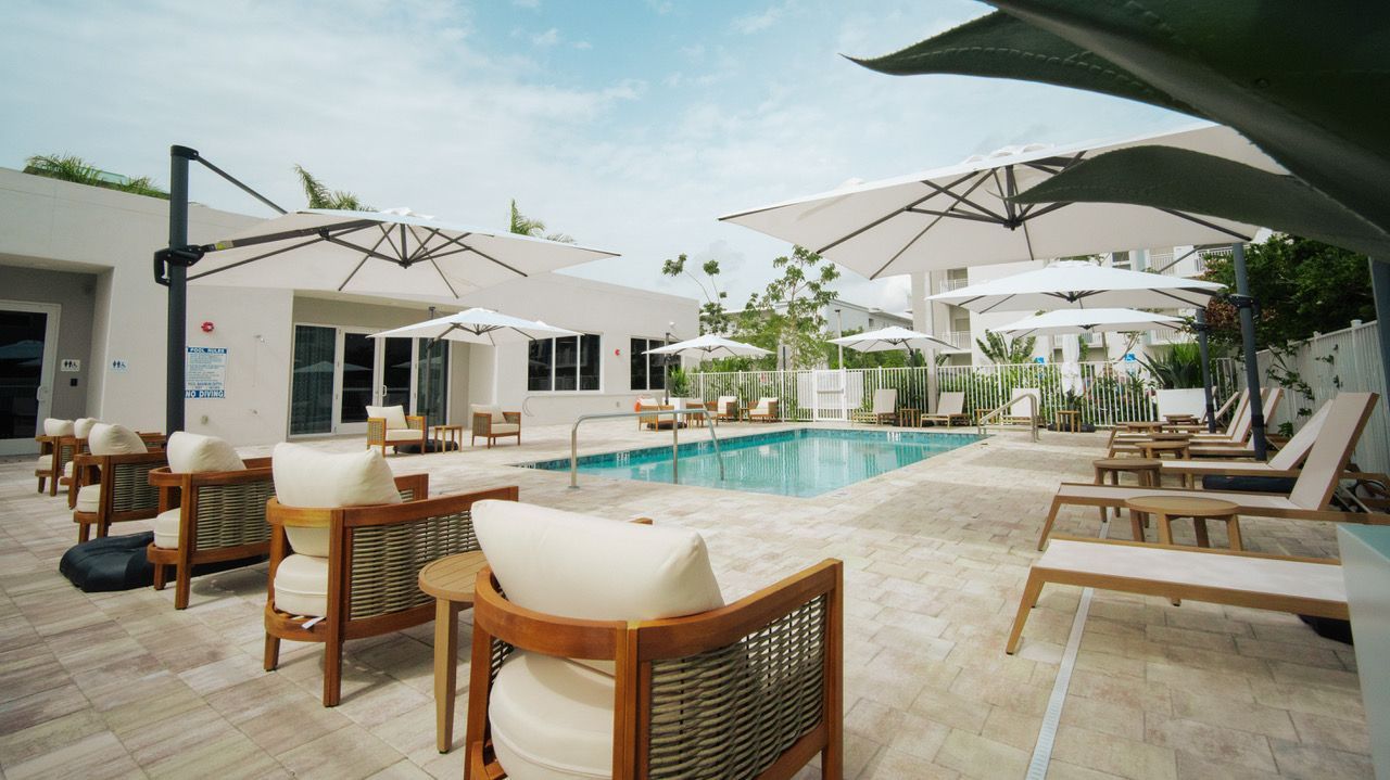 A large swimming pool surrounded by chairs and umbrellas