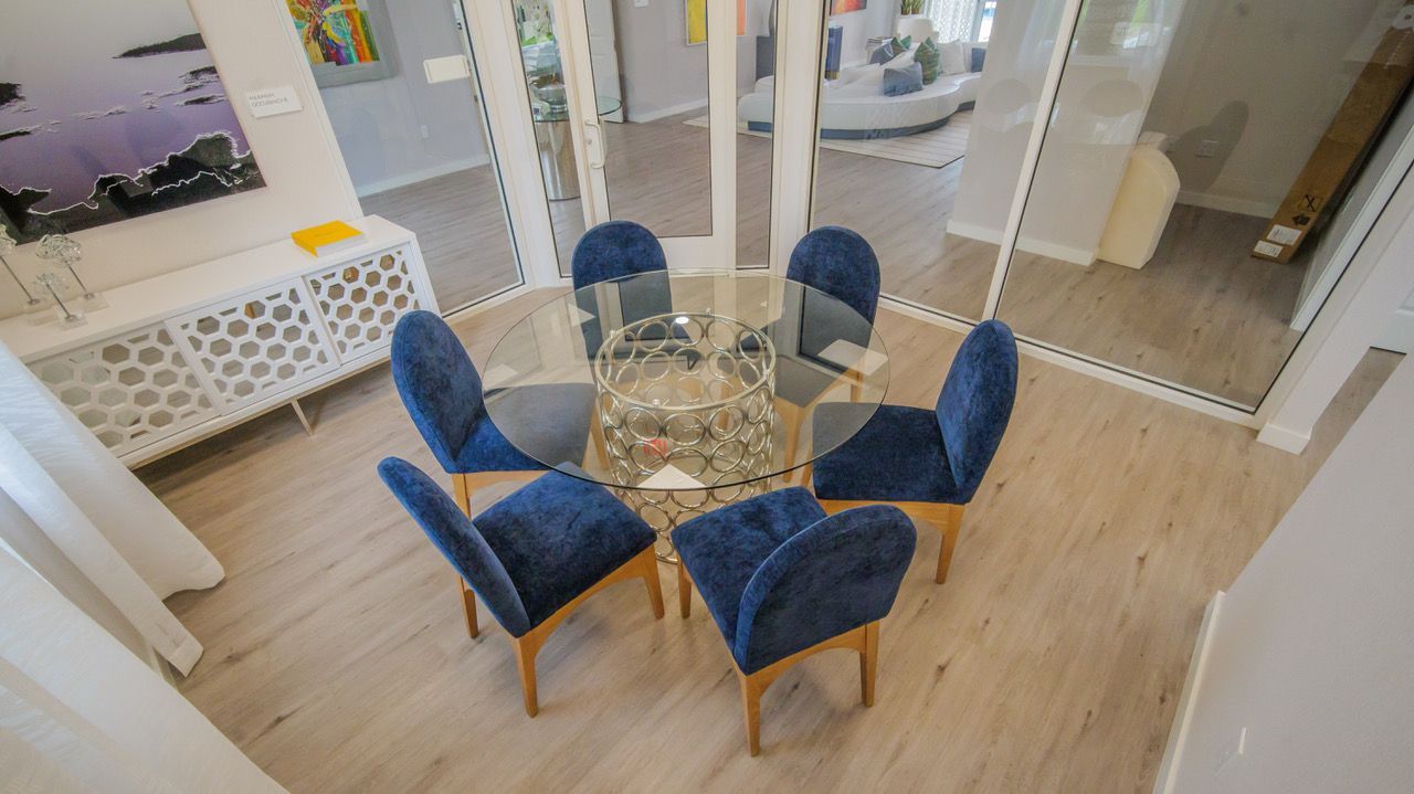 An aerial view of a dining room with a round table and blue chairs.