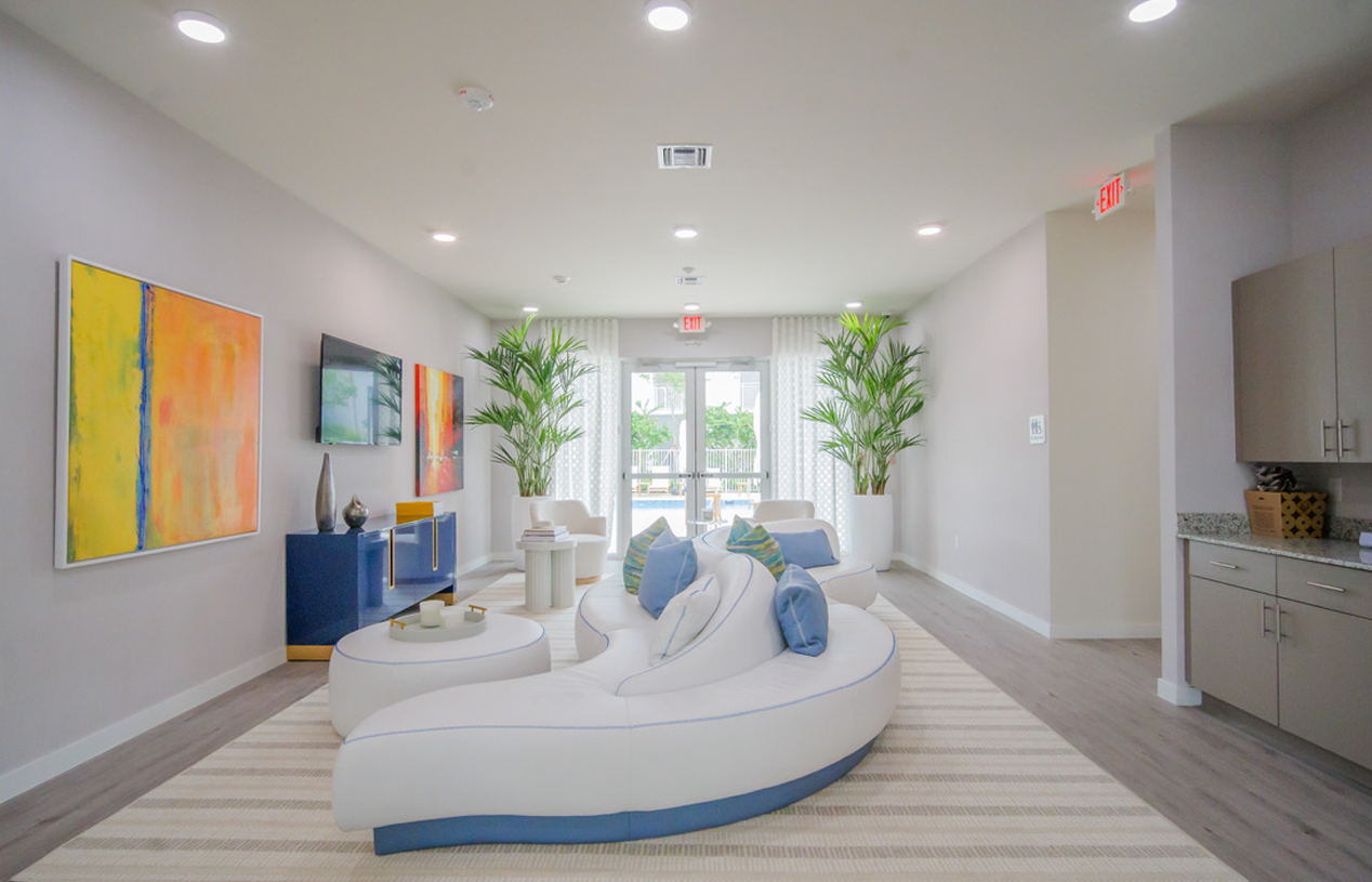 A club room with a couch , chairs , and a television.