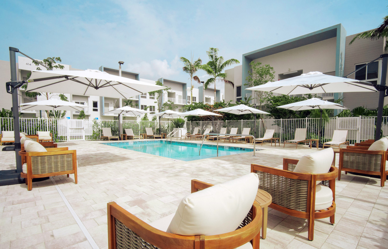 A large swimming pool surrounded by chairs and umbrellas