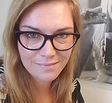 Et nærbillede af en kvinde iført briller og smilende.