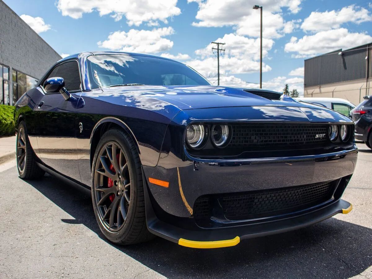 Blue Dodge Challenger parked on a sunny day. Black grille, yellow splitter, red brake calipers.