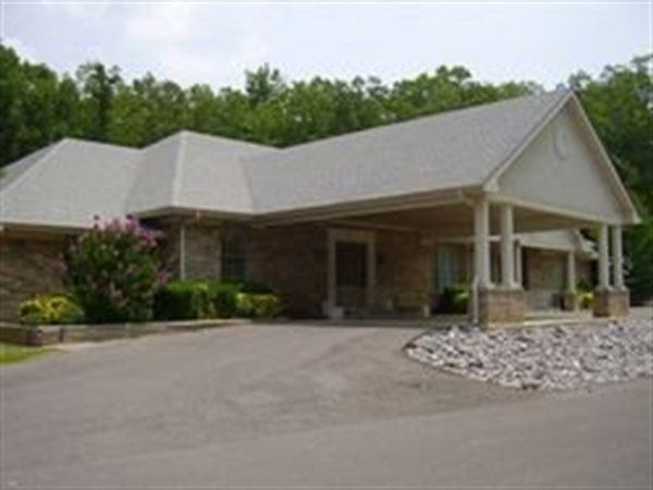 The front door of a house with a porch and plants in front of it.