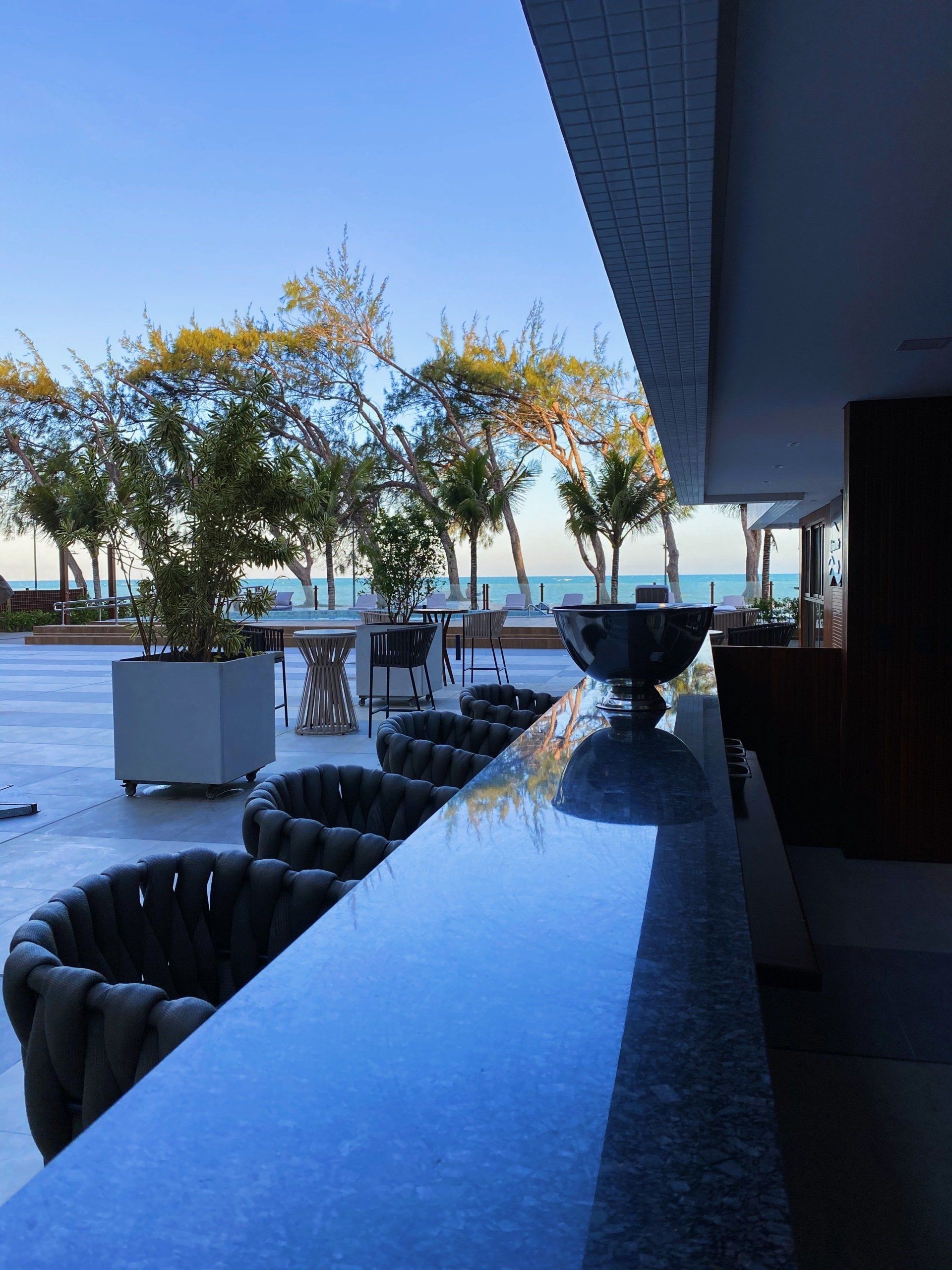 Um bar com vista para o oceano e as árvores