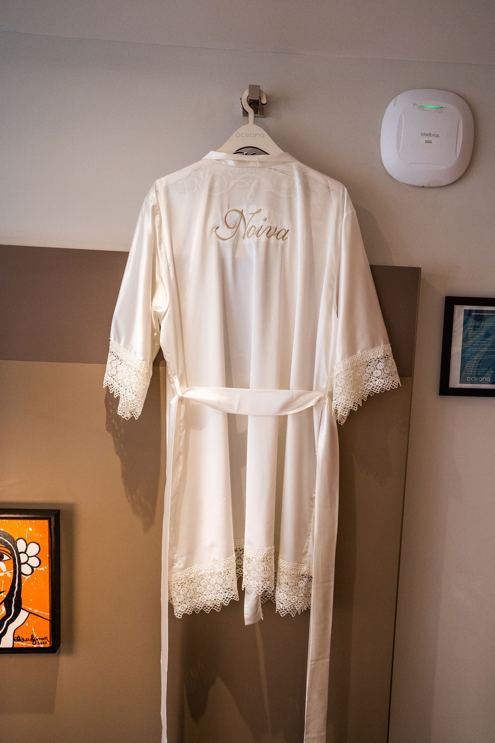 Um manto branco está pendurado num cabide em uma sala.