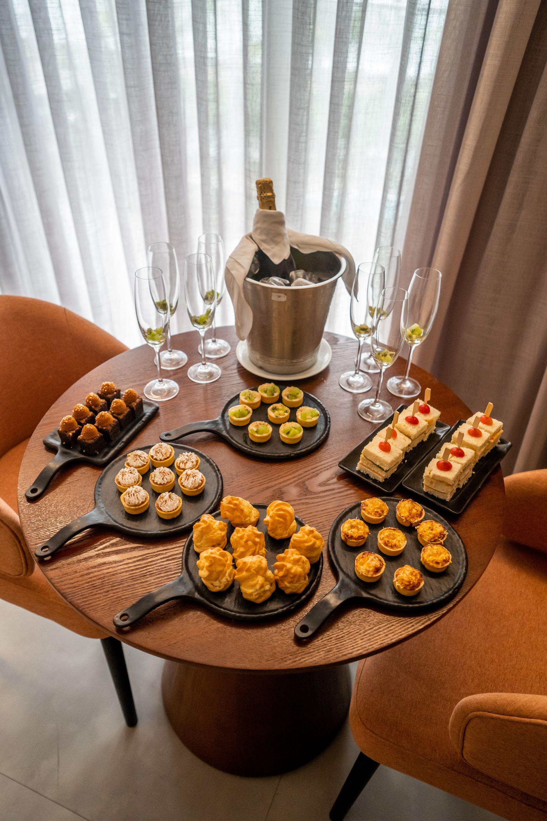 Uma mesa de madeira coberta com pratos de comida e taças de vinho.