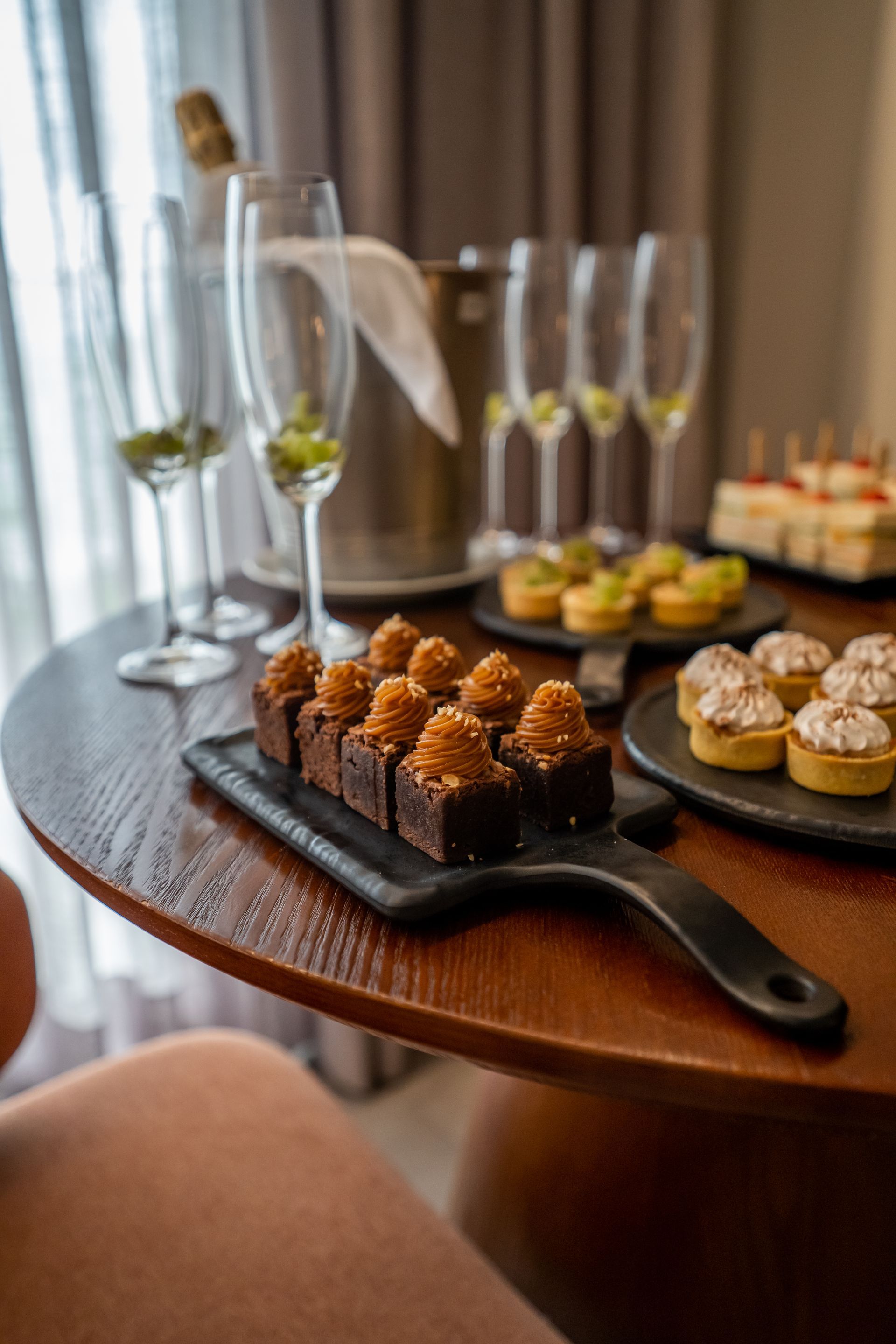 Uma mesa de madeira coberta com pratos de comida e taças de vinho.