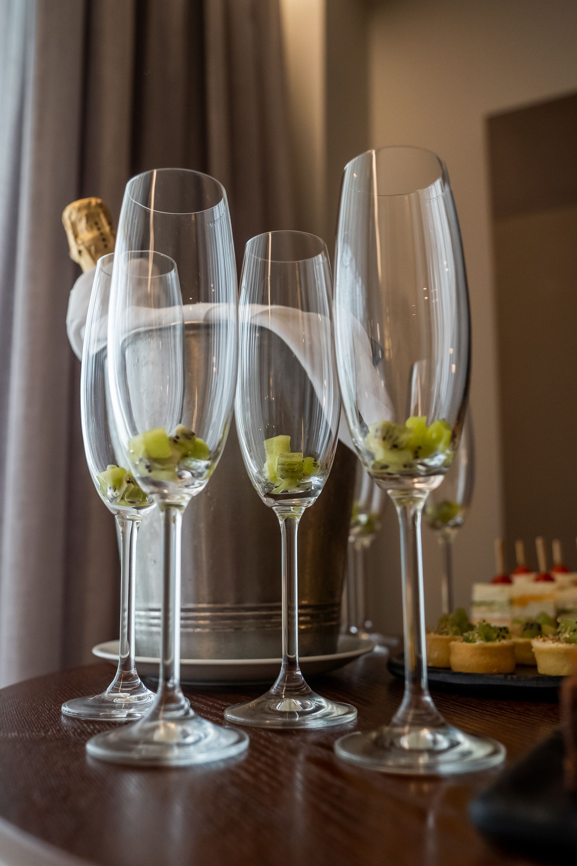 Uma mesa coberta com taças de champanhe e um balde de champanhe.