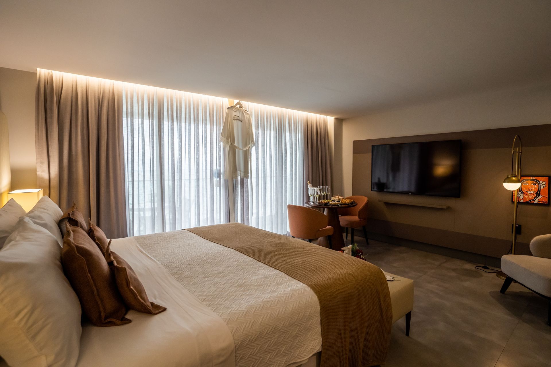 Um quarto de hotel com uma cama grande e uma TV de tela plana.