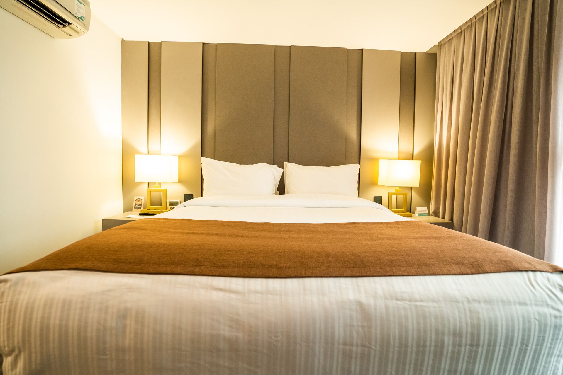 Um quarto de hotel com uma cama king size e uma janela.