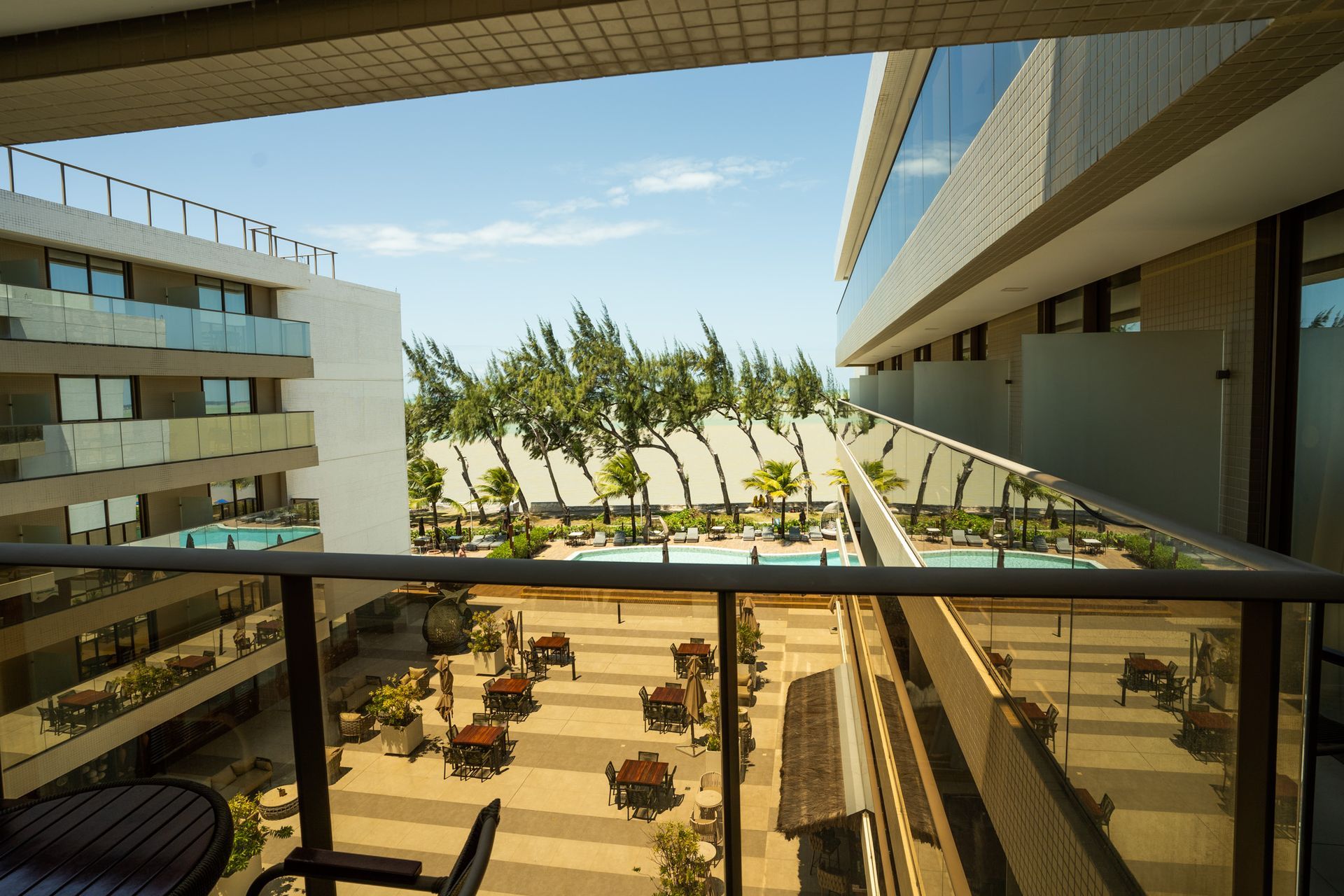 Uma varanda com vista para um prédio e uma piscina