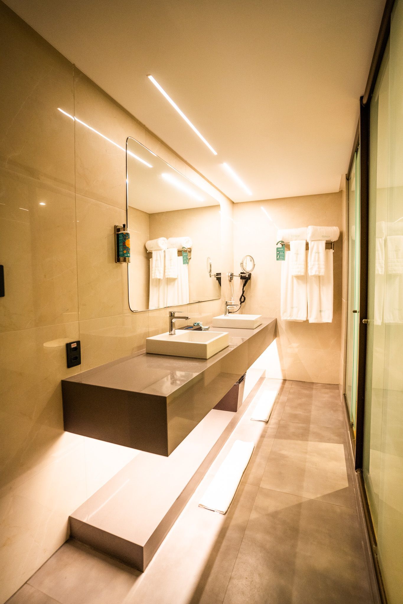 Um banheiro com duas pias e um espelho.